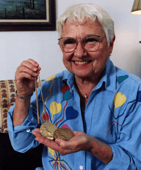 Betty Robinson agée et souriante en présentant ses deux médailles d'or olympiques